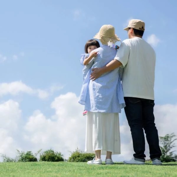 青空を背景にたたずむ家族